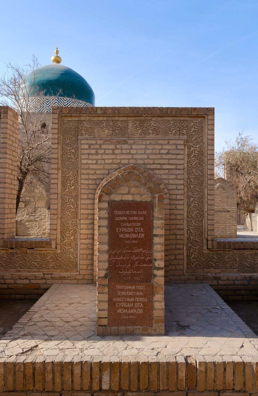 A historic brick archway with a green dome in a sunlit ancient complex · Karakalpakstan, Uzbekistan