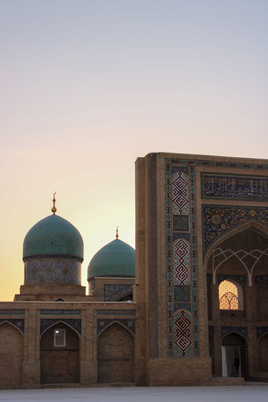 Mosque with intricate blue domes and archways at sunrise, capturing Islamic architecture · Karakalpakstan, Uzbekistan