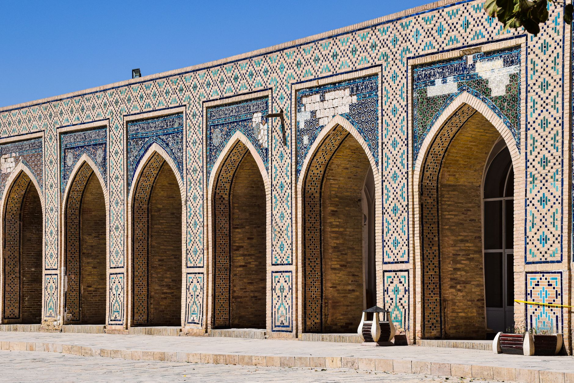 Detailed view of the intricate arches and mosaic tiles of a historic mosque in Bukhara, Uzbekistan · Karakalpakstan, Uzbekistan