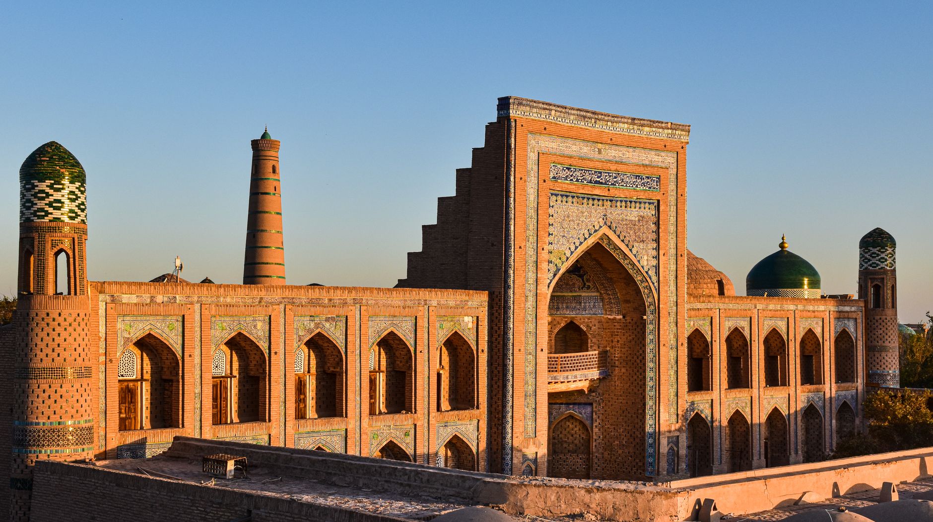 View of Mohammed Rakhim Khan Madrassah in Khiva with a clear sky at sunset · Karakalpakstan, Uzbekistan