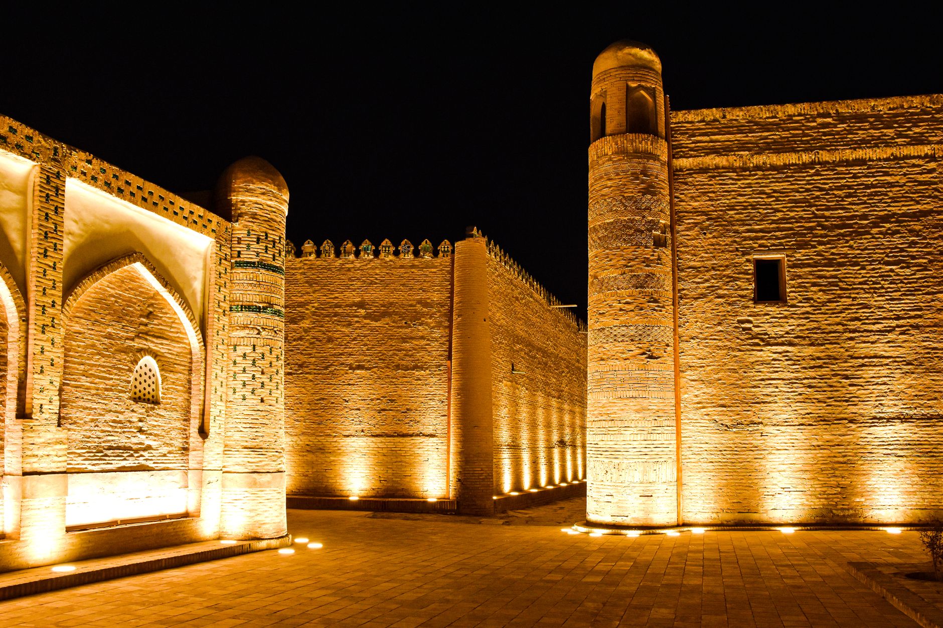 A beautifully lit historic wall in Khiva, Uzbekistan, showcasing Islamic architecture at night