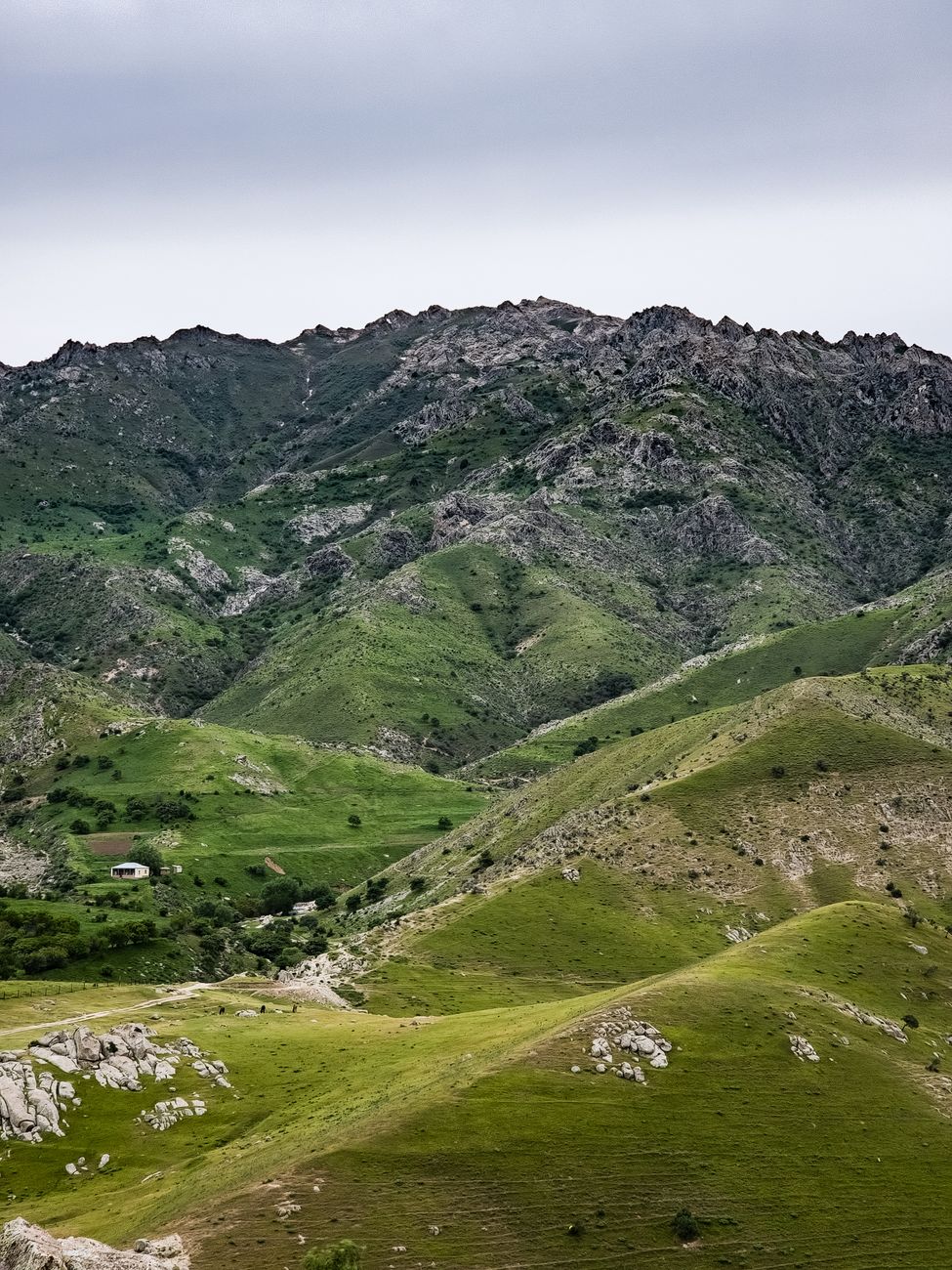 Lush green mountains under a cloudy sky, capturing the essence of Uzbekistan's natural beauty · Chimgan & Charvak, Uzbekistan