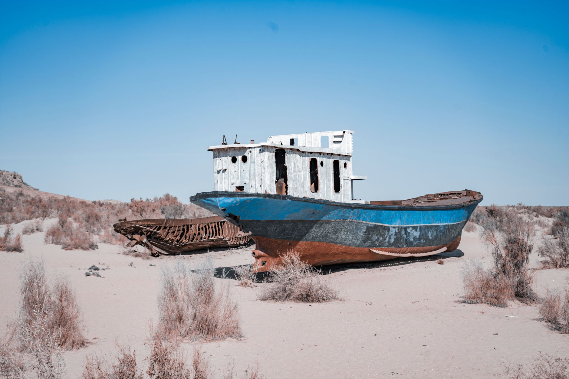 Rusty abandoned ships stranded on the Aral Sea desert, highlighting environmental disaster effects · Karakalpakstan, Uzbekistan