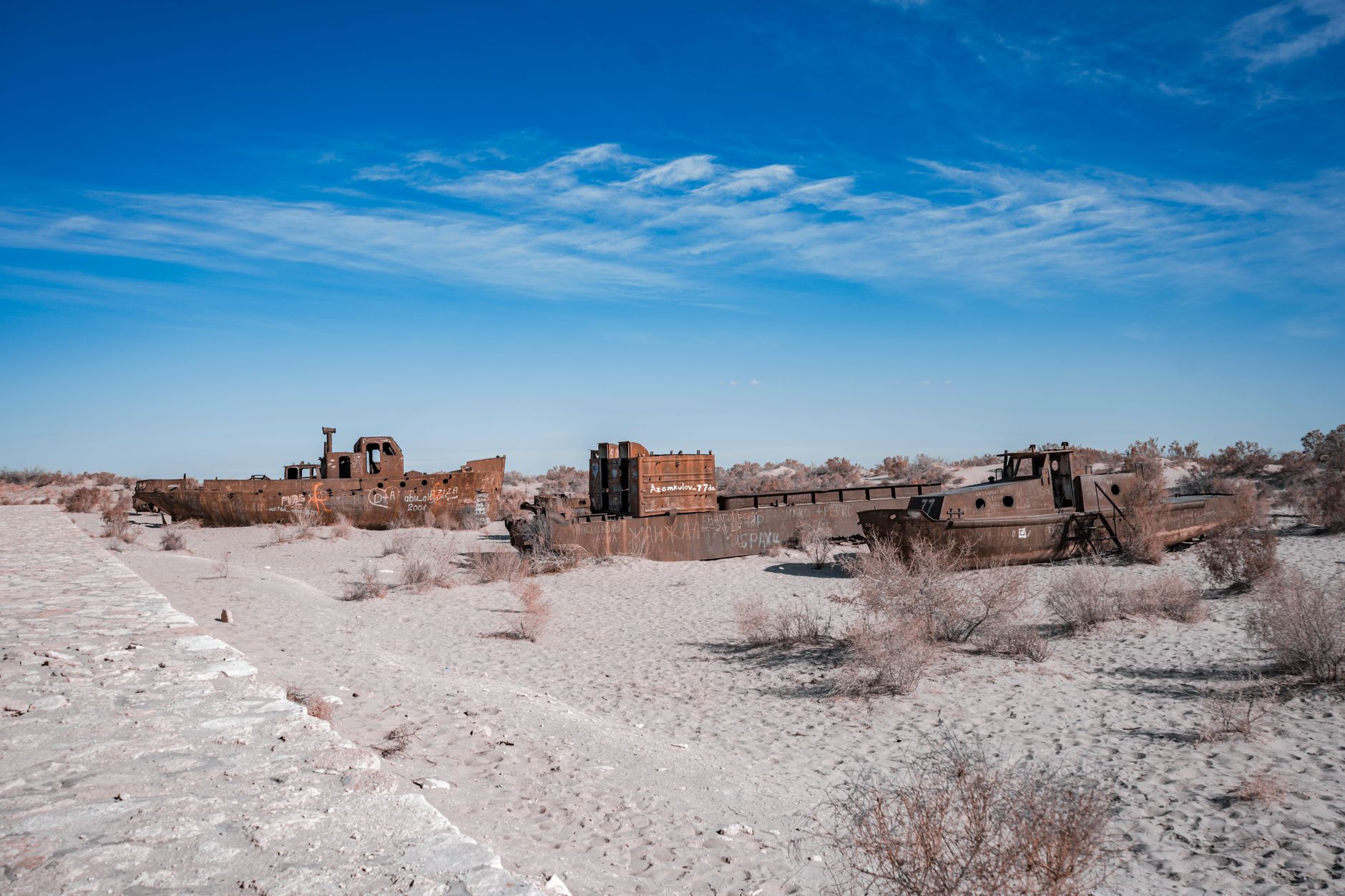 Rusty ships stranded on the desert sands of the Aral Sea, showcasing environmental deterioration · Muynak & the Aral Sea, Uzbekistan