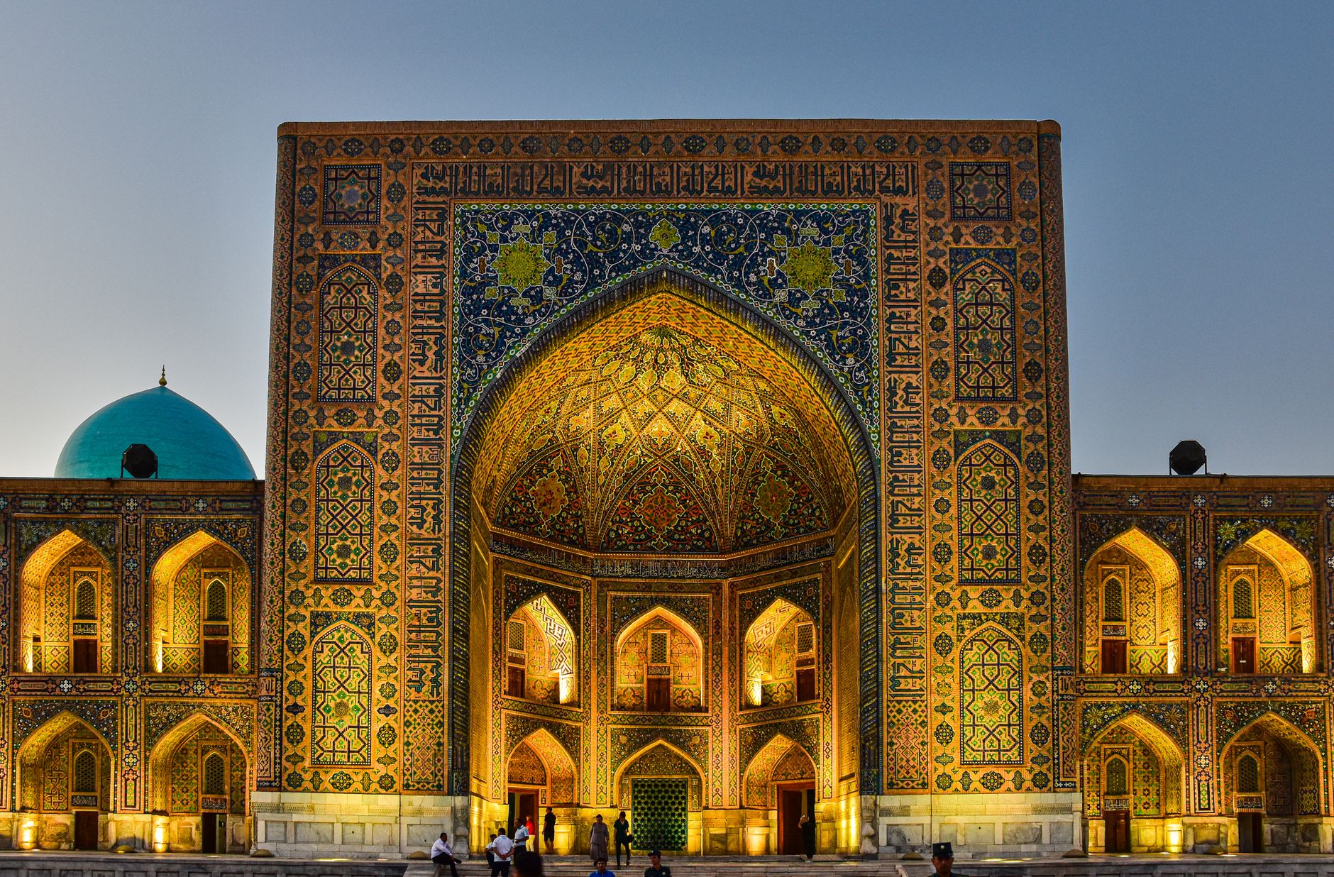 Tilya Kori Madrasah in Samarkand, Uzbekistan, illuminated at twilight, showcasing intricate Islamic architecture