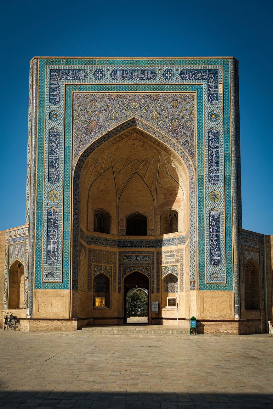 Beautifully detailed facade of Mir-i-Arab Madrasa in Bukhara under clear blue skies · Shakhrisabz, Uzbekistan