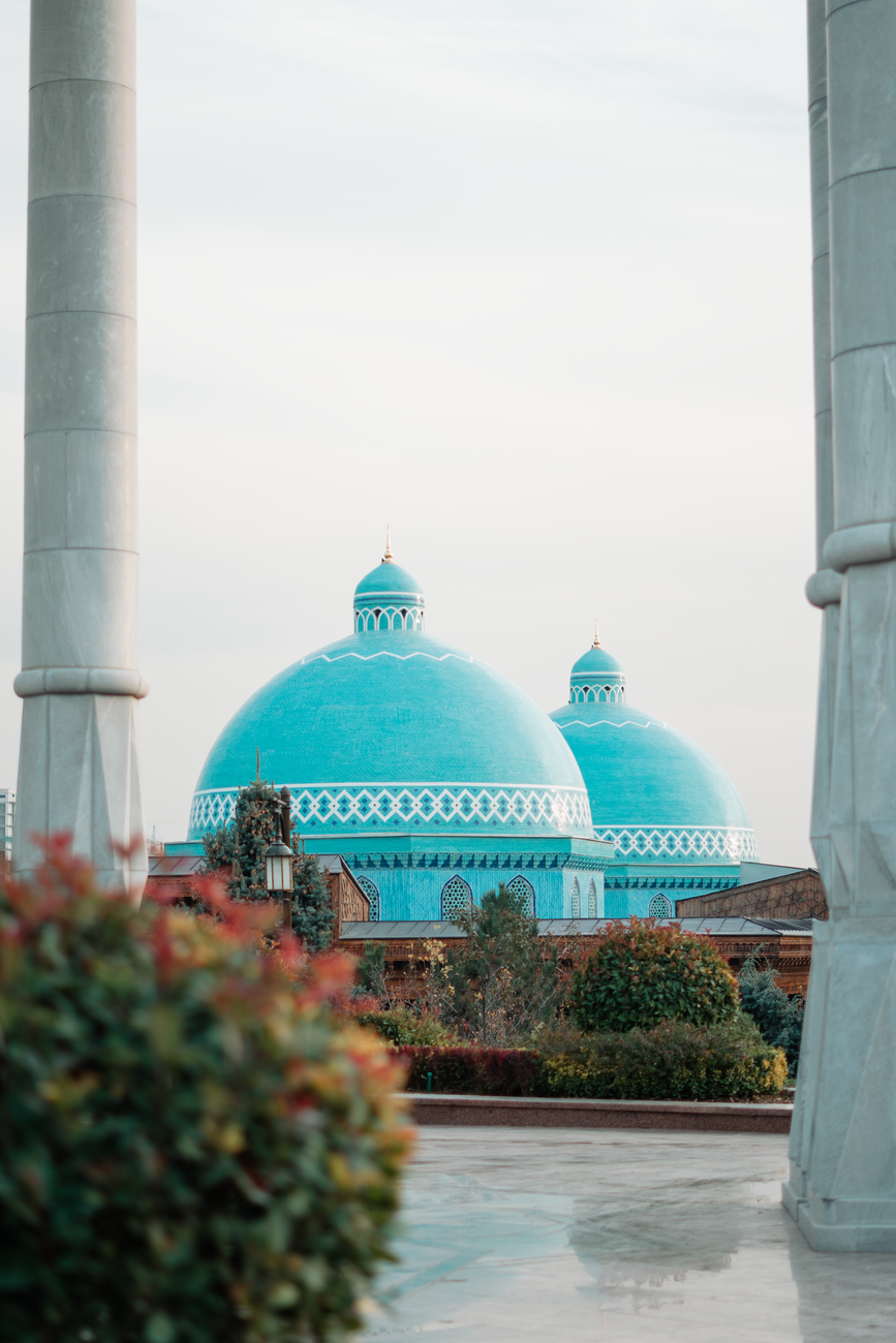 View of the blue domes of a mosque in Tashkent, Uzbekistan, framed by columns