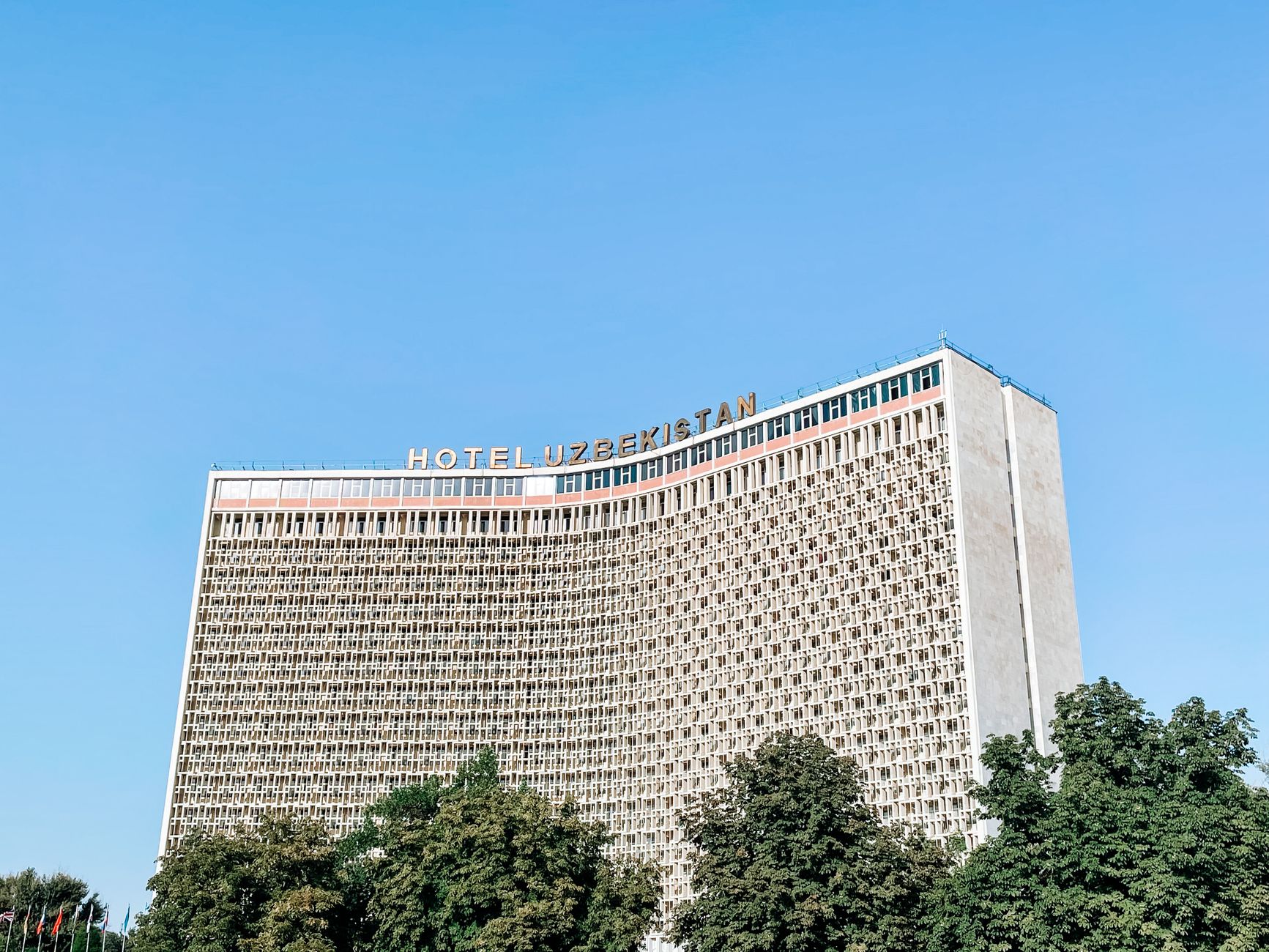 A striking view of the Hotel Uzbekistan facade under a clear blue sky