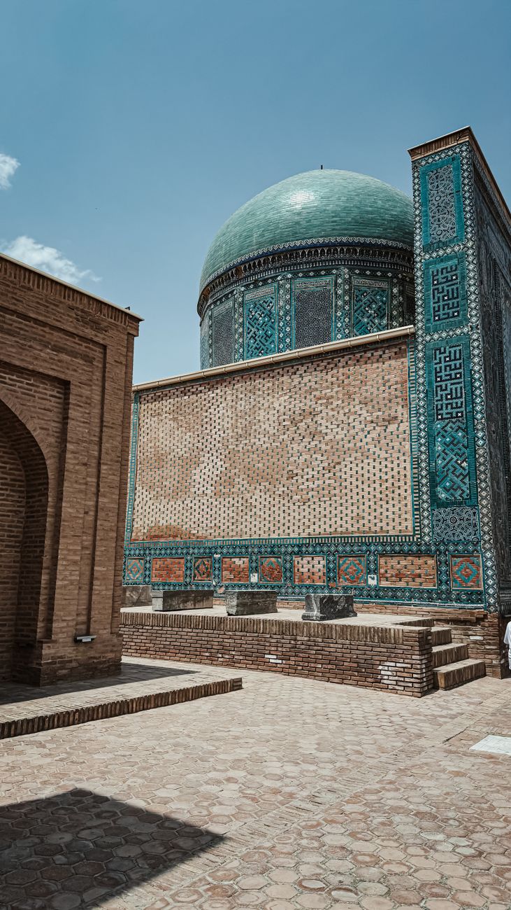 Islamic architecture with intricate tile work and a green dome on a sunny day, Uzbekistan