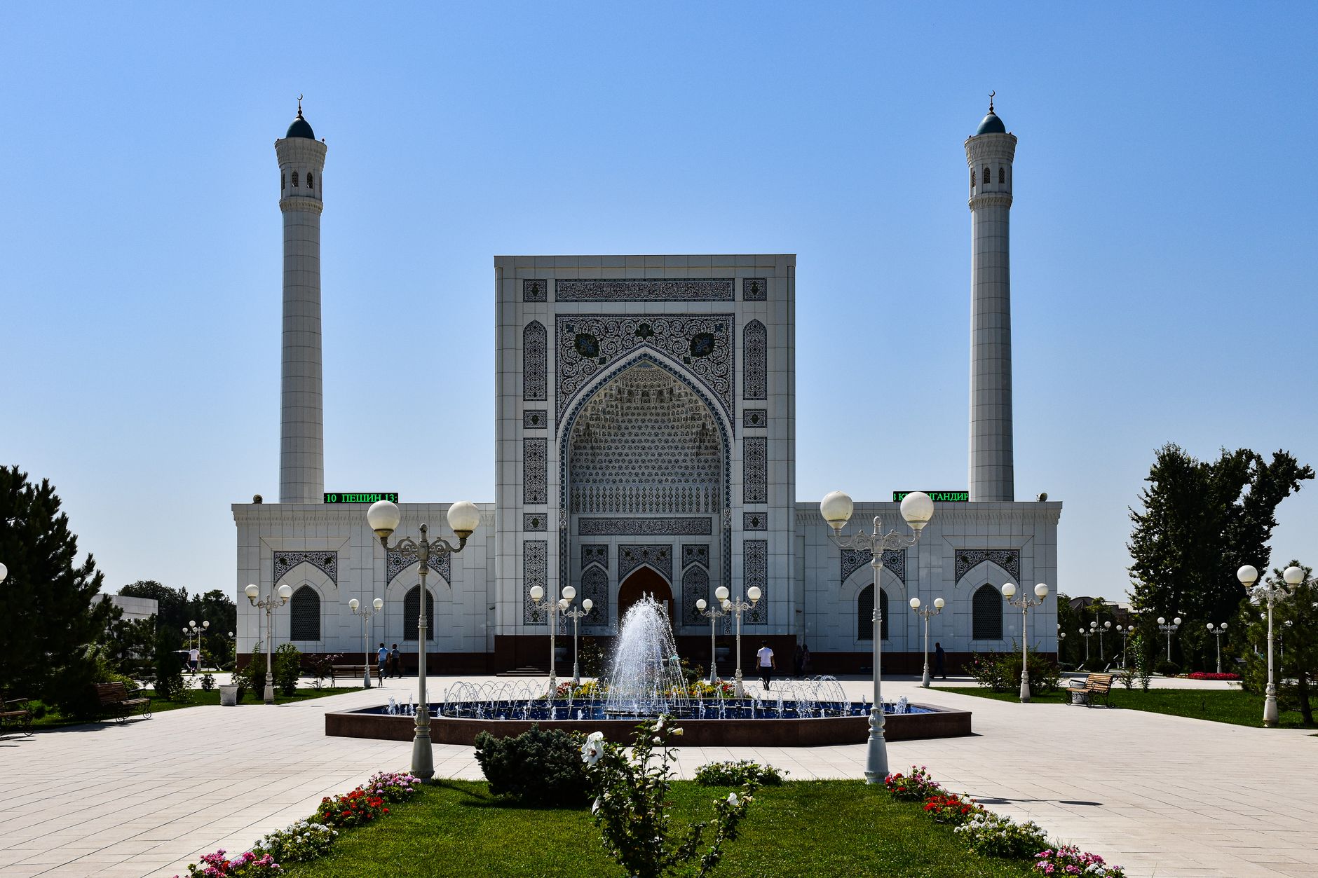 Mosque with intricate design and fountains under a clear blue sky, Uzbekistan