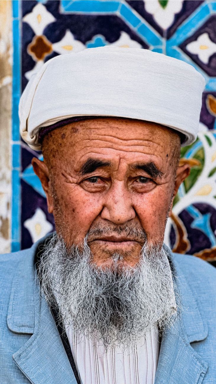 Close-up portrait of an elderly man with a traditional cap in Bukhara, Uzbekistan. Vibrant background art