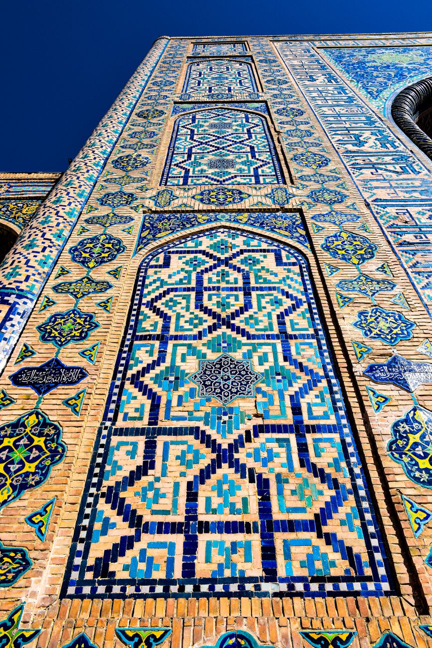 Vertical shot of intricate mosaic patterns on a historic Islamic architectural facade, showcasing vibrant colors, Uzbekistan